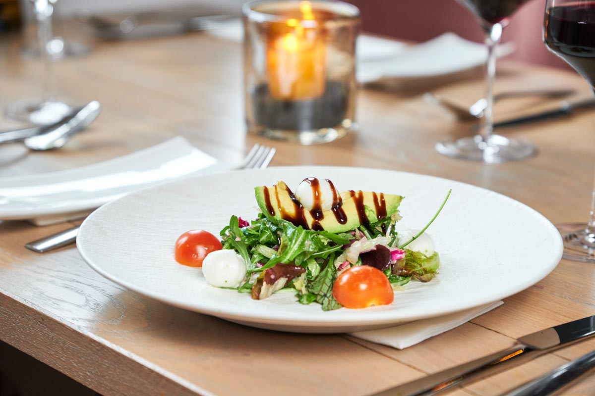 Avocado gevuld met tomaat en mozzarella op een bord